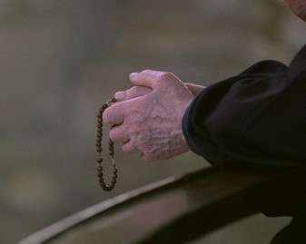 Un vieux moine prie le chapelet